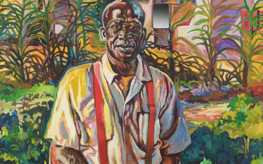 An African American man stands in the foreground with a colorfully painted garden beyond.