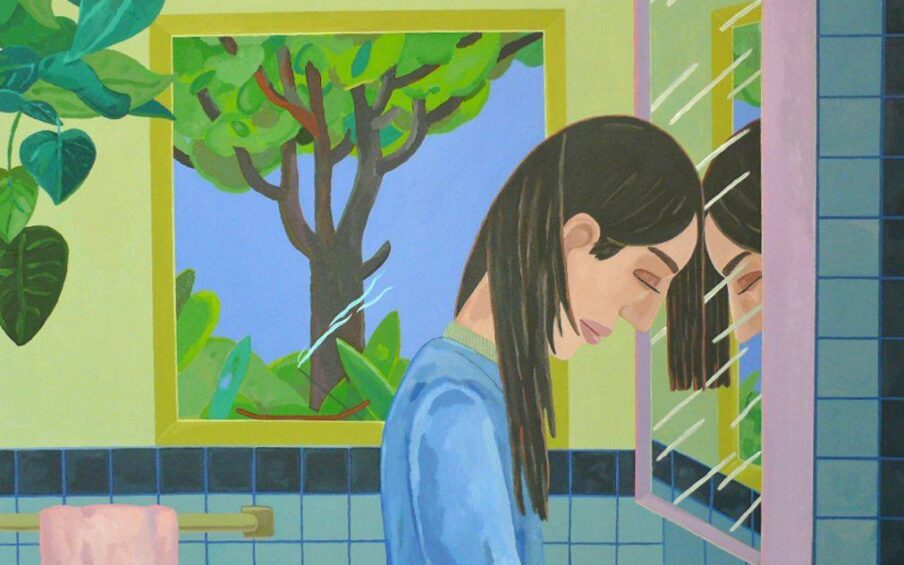 A horizontal, rectangular illustration of a white woman with long brown hair tucked behind her ears, positioned at the right. Viewed in profile, facing right, she leans her forehead against a bathroom mirror. Her eyes are closed. She wears a long-sleeve, light-blue top. She is reflected in the pink-framed mirror, seen with white, diagonal stripes representing the mirror’s glare. Behind her, in the center of the picture, is a window, also with glare streaks in the lower half, showing a tree with dark brown trunk and branches with foliage in various green tones. In the upper-left corner, leafy greens of a house plant are visible. The wall behind the figure is a yellow-green, the window is framed in a slightly darker yellow green. A dark blue horizontal stripe of tile runs along the back wall at chest level to the figure. A pink towel hangs on a bar at left.