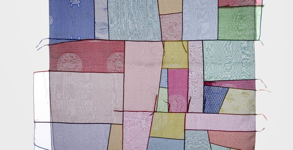 Lee Chunghie, Bojagi, 30x28 5/8 inches, silk and screen print. A square textile composed of varied rectangular shapes in blues, pinks, mauve, burgundy, greens, and gold. Stitching creates dark, thin lines between the transparent fabric scraps giving the work the look of a patchwork quilt. Some blocks of fabric are set side by side, some parallel to each other. A few of the blocks, like the blue and burgundy, have partial patterns visible, such as stripes and circular designs. Almost all of the fabric has a rippled effect to the weave. Some transparent fabric blocks continue beyond the square along with thin ribbons that trail off the edges of the work. Threads and ribbon ends are visible throughout.