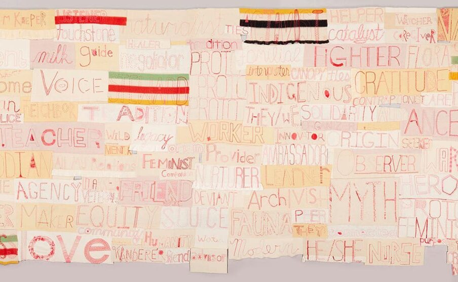 A long rectangular work composed of numerous other horizontally oriented rectangles. Each rectangle contains a word embroidered in red thread on various shades of cream to pale tan cloth in assorted stitches and styles. Some of the largest words are Ancestor, Myth, Love, Voice, Fighter, Custodian, Gratitude. Smaller words include Seeker, Care, Watcher, Legacy, Healer, Advocate, Interpreter, Wild, and Catalyst. Interspersed among the words are rectangles made of striped blankets in red, green, yellow, and black.