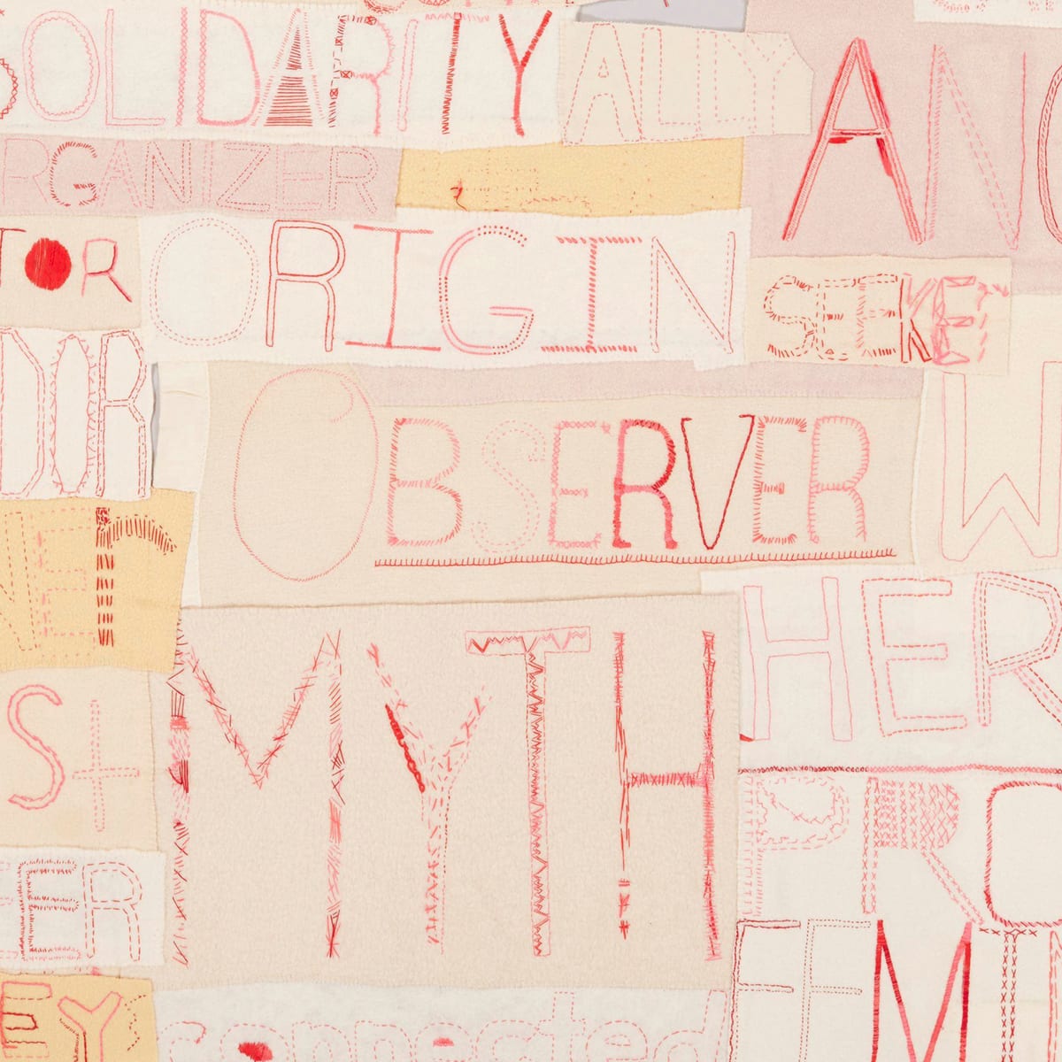 Detail of front: Close-up view of the work showing the words Origin, Observer and Myth surrounded by partial words. A variety of embroidery stitches make up each word. The rectangular patches containing words overlap and are stitched in cream thread.
