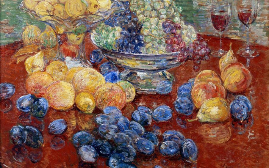Childe Hassam. Oregon Still Life, 25 x 30 ¼ inches, oil on canvas. A painting of an assortment of fruit laid out on a round, dark brown table, the edges of which are mostly out of frame. At top, at 11 and 12 o’clock, are a glass bowl with a tall stand brimming with yellow apples that sits beside a squat, silver bowl holding green, purple, and red grapes. Just below the glass bowl are more yellow apples, some with a hint of pink. Further down the painting and scattered over the table are deep blueish-purple plums. At three o’clock are a grouping of half dozen peaches and pears set near two half-filled glasses that suggest wine. The painting technique is bold and uses dry brush strokes. Paint is heavily layered, revealing the colors underneath in areas. The table and fruit are set against a background heavily painting with horizontal strokes in muted greens, terra cotta, whites with deep yellow. Image description 2: An overhead view of a silver, wide lipped pan containing a golden cake brimming with plums.