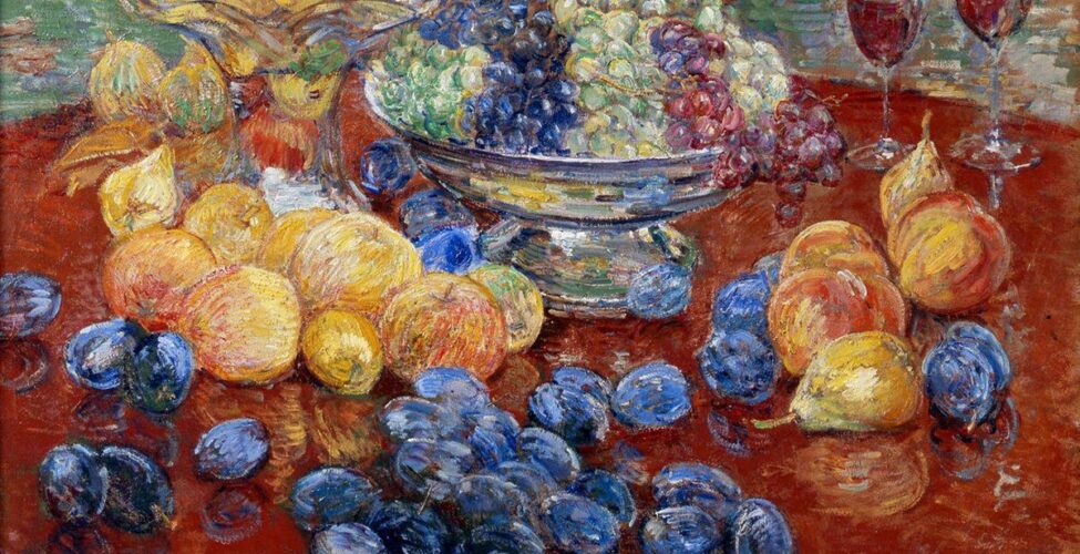Childe Hassam. Oregon Still Life, 25 x 30 ¼ inches, oil on canvas. A painting of an assortment of fruit laid out on a round, dark brown table, the edges of which are mostly out of frame. At top, at 11 and 12 o’clock, are a glass bowl with a tall stand brimming with yellow apples that sits beside a squat, silver bowl holding green, purple, and red grapes. Just below the glass bowl are more yellow apples, some with a hint of pink. Further down the painting and scattered over the table are deep blueish-purple plums. At three o’clock are a grouping of half dozen peaches and pears set near two half-filled glasses that suggest wine. The painting technique is bold and uses dry brush strokes. Paint is heavily layered, revealing the colors underneath in areas. The table and fruit are set against a background heavily painting with horizontal strokes in muted greens, terra cotta, whites with deep yellow. Image description 2: An overhead view of a silver, wide lipped pan containing a golden cake brimming with plums.