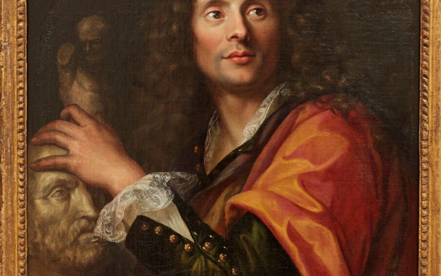 Portrait of a Sculptor, Gabriel Revel, 26 ¼ x 22 ¼, oil on canvas. A vertical rectangular portrait of a man in 17th century dress posing with sculpture. The man is depicted in three quarter view from the waist up with his shoulder turned towards the viewer. His arm crosses in front of him and his hand rests on a sculpture. His body is turned towards the left and he gazes off to the right. The man is light-skinned with large brown eyes, full lips and long, full, curly brown hair that falls well past his shoulders. He wears a brownish-black coat that is open at the throat over a white shirt with lace at the collar and cuffs. Round brass buttons line the front and cuff of the coat. Draped over his shoulder is a length of red shiny fabric. His hand rests on a bust of a bearded man while another statuette stands in the dark background. The four corners of the painting are clipped to create an elongated octagon shaped canvas.