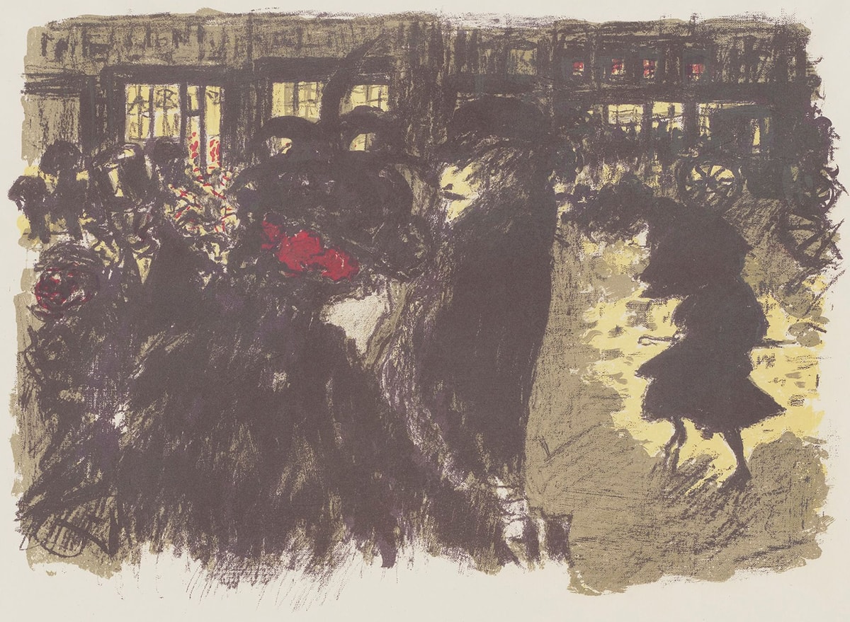 Image description: Pierre Bonnard, The Square at Evening, 1899, Color lithograph on cream paper, 16 x 20 ⅞ in. A large group of people walk through the square alongside stage coaches in front of large buildings with bright light shining from the windows. Heavy, layered strokes make up the images with details that are difficult to differentiate. A light-skinned woman wearing a black cape, large black hat with feathers protruding from the top, and red bows in her hair faces away from the viewer and takes up a two-thirds of the bottom of the lithograph. To the right a tall, thin, light-skinned man with a mustache and black coat and hat walks towards the left side of the lithograph. Behind him a shorter, thin woman with light skin looks downward and carefully steps forward while wearing a long black dress and a black hat. Yellow light reflects in the puddles around her. Behind her to the right two stage coaches drive off the paper. A large group of figures that cannot be distinguished mill about in front of the lighted windows of the large buildings. Four windows on the second floor are illuminated with reddish orange lights.