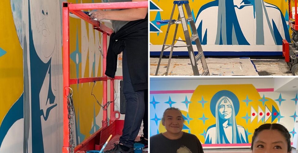 Image descriptions, clockwise from left: 1. A collage of three photos showing the artist Lynette Haozous and her assistant, Andrew Benally working on a mural. The first photo takes up the space on the left and features Haozous standing on a motorized lift painting the eye of a partially painted figure on the museum wall. Haozous stands on the red lift facing left, her right hand holding a brush touching the wall. Haozous is a Native American woman with dark hair swept back into two braids. She wears a gray sleeveless top and jeans with a dark shirt tied around her waist and black sneakers. A pot of blue paint sits at her feet. The mural taking shape on the wall portrays the head and shoulders of a larger-than-life figure with long hair in blue and gray. The figure is set against a bright yellow background with a halo-like shape around the head. Light blue four, pointed stars with white circle in their centers surround the figure. Two more photos are stacked on the right. 2. The top features the mural in progress with a table, ladder, and motorized lift in front of it. The mural’s central figure is the head and shoulders of a figure with long straight hair rendered in blues and grays. The figure gazes directly ahead, with facial features and clothing rendered in light blues on white. A darker blue halo is around the head within a much larger bright yellow organic cloud-like shape. Layered over this are light blue four-pointed stars in rows on either side of the figure. To the left of the figure, four dark blue, pyramid shaped triangles outlined in white are stacked on top of one another. The top and bottom triangles have large white dots in their centers and the middle two have red dots. To the right of the figure are four more pyramid shaped triangles, this time with red center dots and standing on their sides. The floor beneath the mural is covered with drop cloths. 3. The final photo at bottom right shows the artist and her assistant in the foreground with the completed mural in the background. Assistant Andrew Benally, a Native American man, stands at left, smiling. His hair is pulled back and he wears a black t-shirt with a figure in white wearing a feathered headdress. The artist Lynnette Haozous, stands at right, also smiling at the camera off to the right. She wears her hair back in braids, a plaid shirt and peach t-shirt. Behind them the mural is displayed next to a window with natural light.