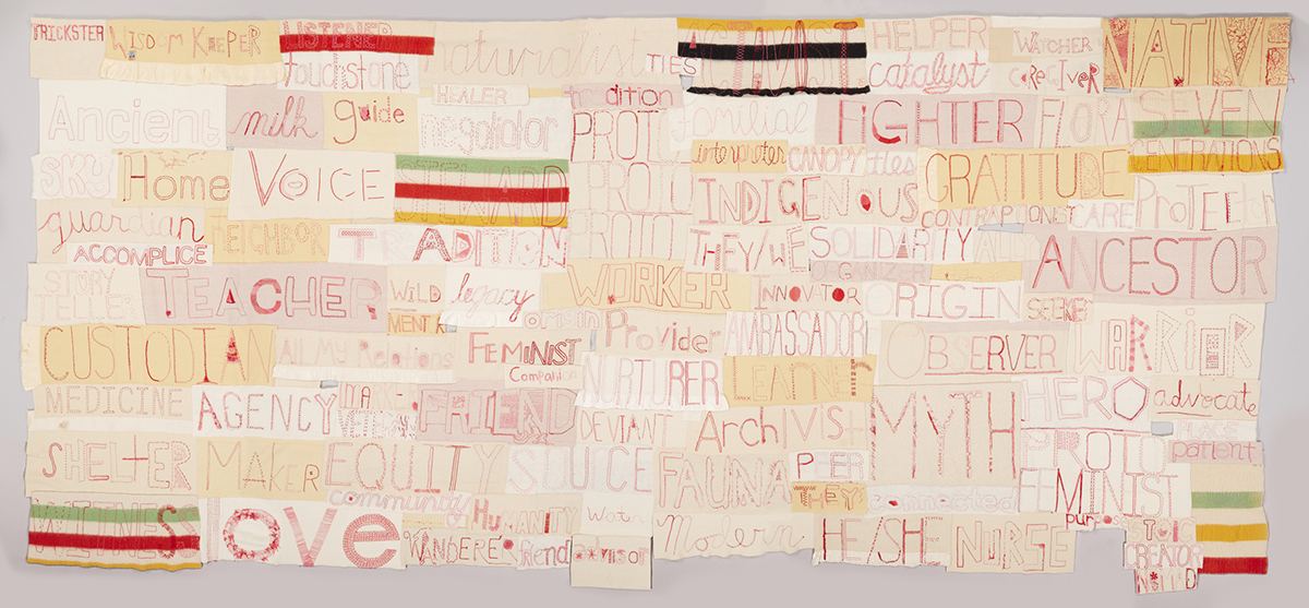 Image description: Companion Species: Ferocious Mother and Canis Familiaris. Marie Watt. 2017. Reclaimed wool blankets, embroidery floss, and thread. 108 in x 217 in. A long rectangular work composed of numerous other horizontally oriented rectangles. Each rectangle contains a word embroidered in red thread on various shades of cream to pale tan cloth in assorted stitches and styles. Some of the largest words are Ancestor, Myth, Love, Voice, Fighter, Custodian, Gratitude. Smaller words include Seeker, Care, Watcher, Legacy, Healer, Advocate, Interpreter, Wild, and Catalyst. Interspersed among the words are rectangles made of striped blankets in red, green, yellow, and black.