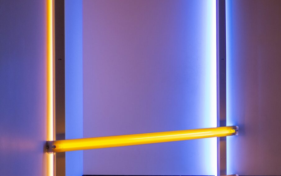 Image description: Untitled (to Donna) 2, 96 ¼ x 96, fluorescent light. An installation of fluorescent lights positioned in a corner consisting of two bright yellow lights running horizontally at floor and knee level and two fluorescent lights running horizontally at each end with the light component facing the wall. The horizontal lights are bright blue at the right and mauve at the left. All four lights cast their colors on the corner walls and floor.