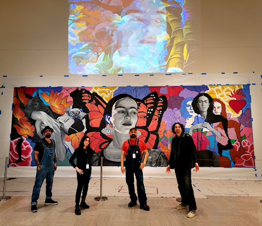 Christian J. Barrios, Angennette Escobar, Hector H Hernandez, Victor Hugo Garzo stand before Metamorphosis Mural in progress and a digital mural