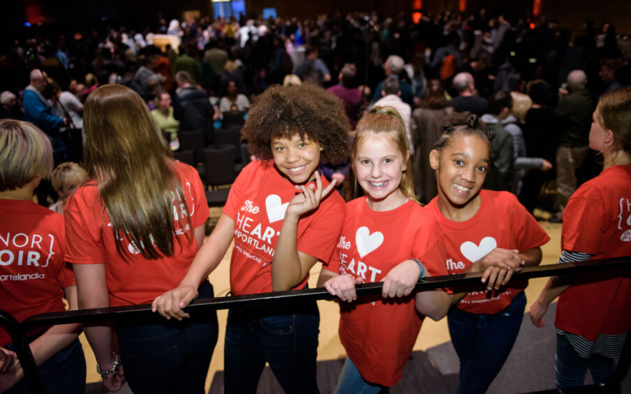 Photograph of three smiling young girls in red t-shirts that read "The Heart of Portland"