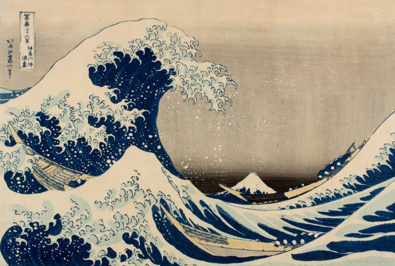 Color woodblock print of an ocean scene with a large waves and three boats.
