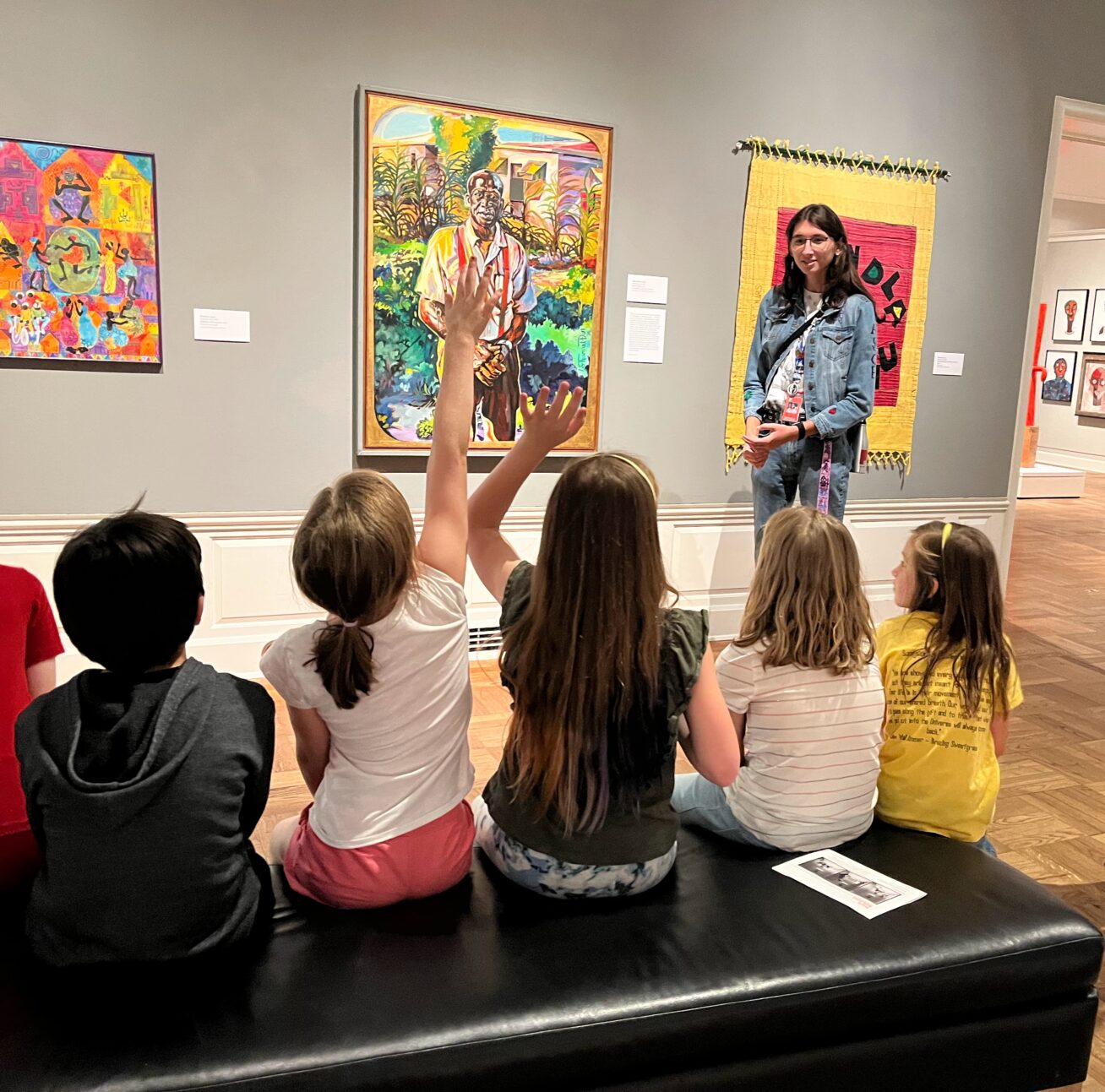 Photograph of a group of kids sitting listening to an educator in the Black Artists of Oregon exhibition