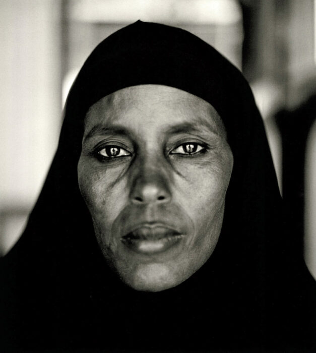 Sepia portrait of a woman in a hijab looking directly into the camera