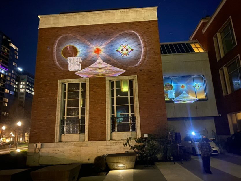 Exterior of Portland Art Museum at night with images projected on the walls