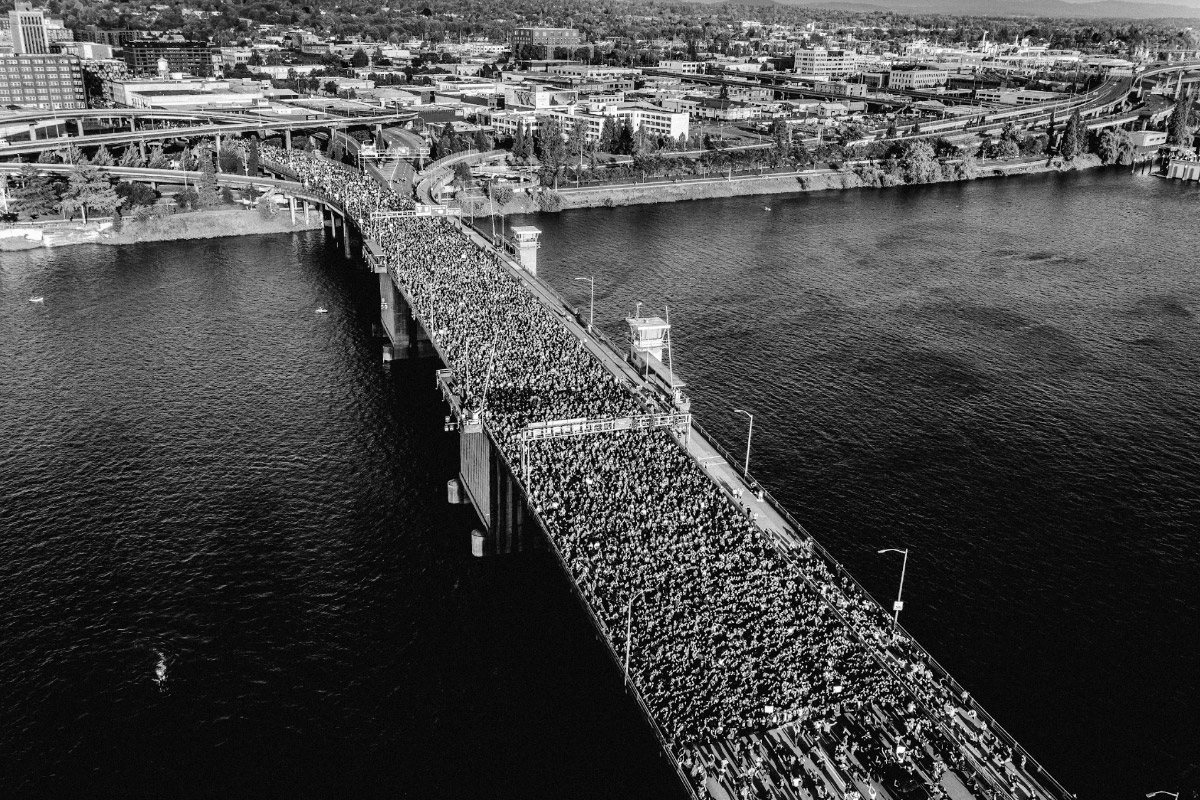 Black and white photo of a bridge from above. The bridge is packed with protesters.