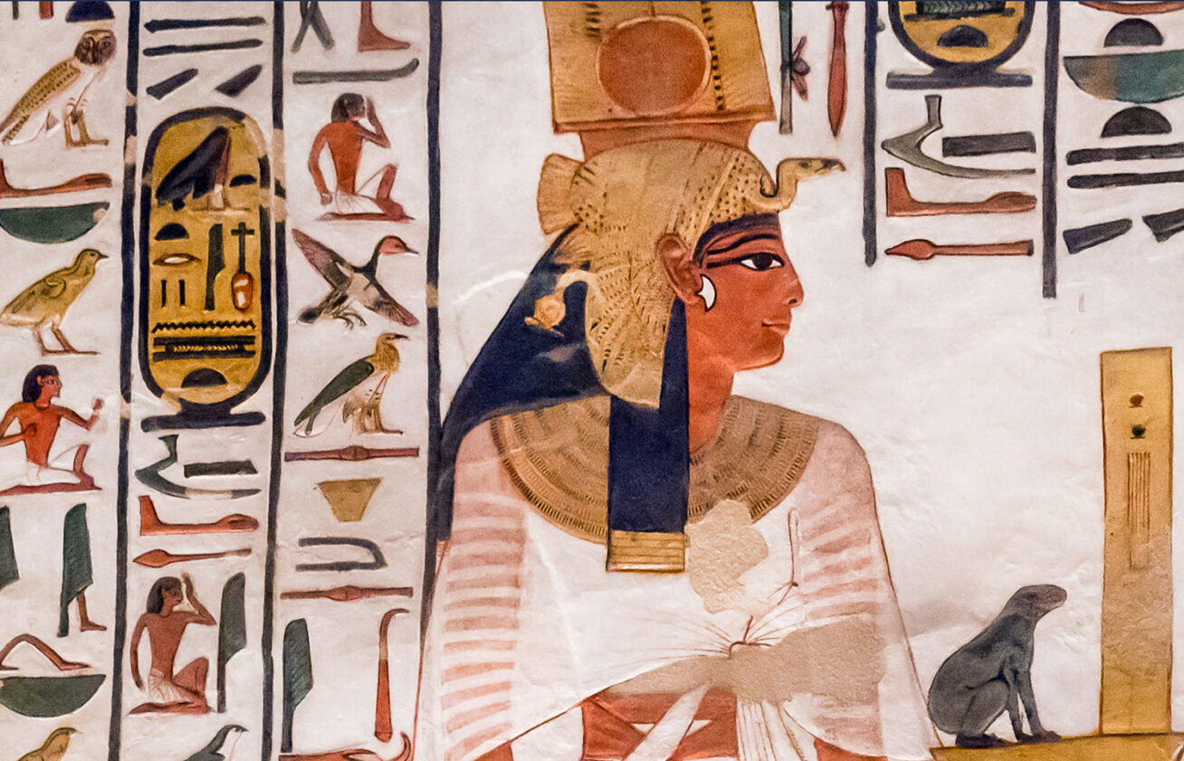 Image of an Egyptian person in a gold headpiece, surrounded by hieroglyphs