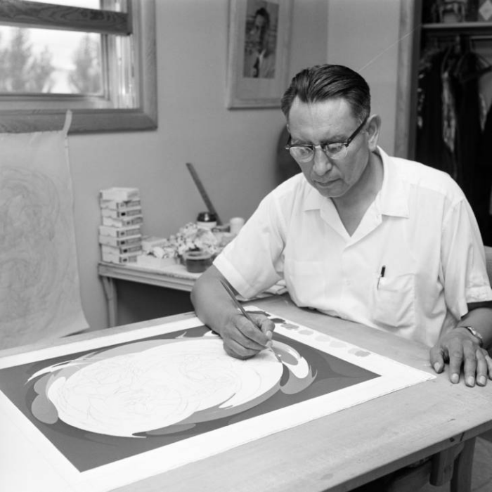Black and white photo of artist Oscar Howe in his studio, ca. 1968