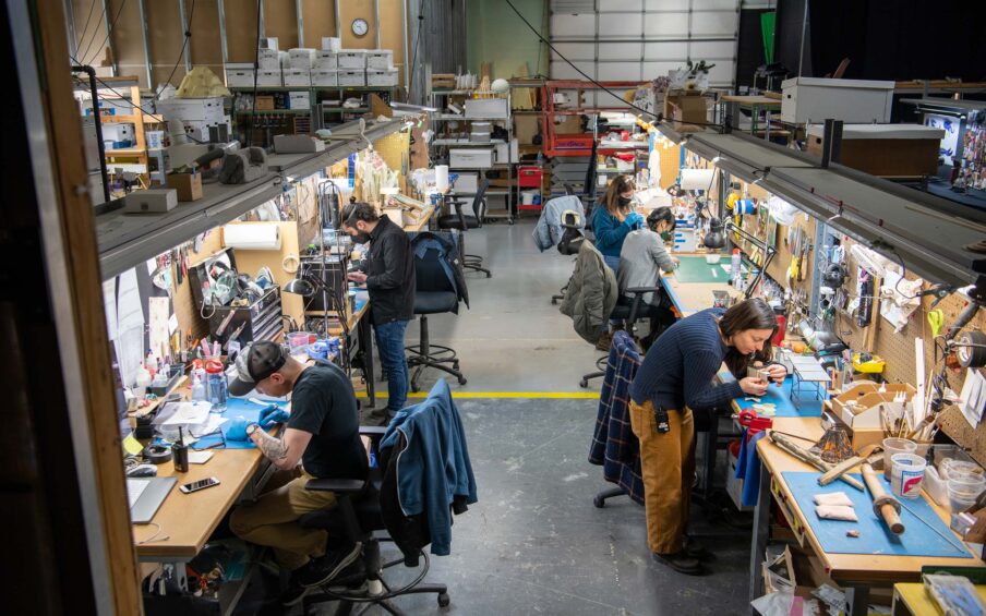 Row of stop-motion artists working in two rows in a warehouse space
