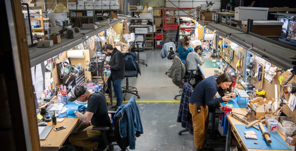 Row of stop-motion artists working in two rows in a warehouse space
