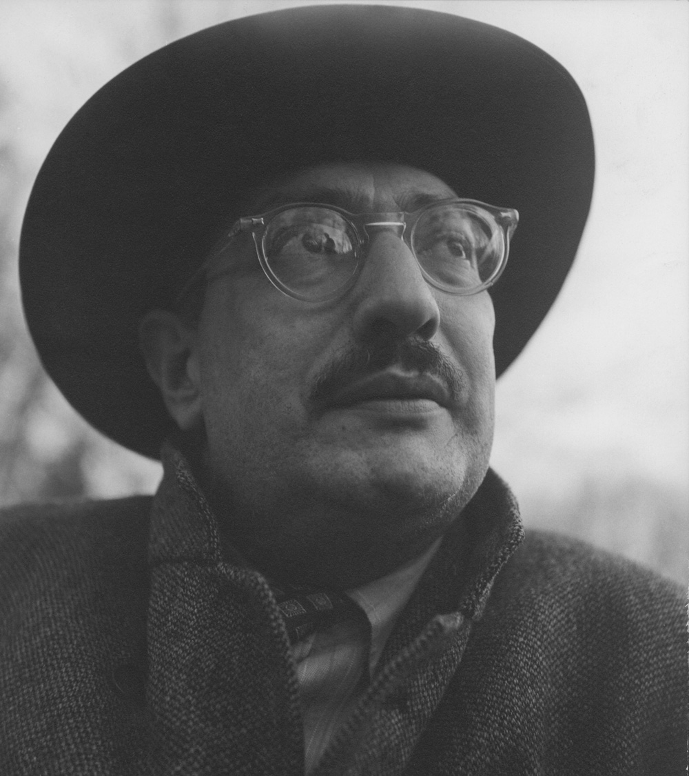 Black and white photo of Mark Rothko wearing clear eyeglasses and a brimmed hat
