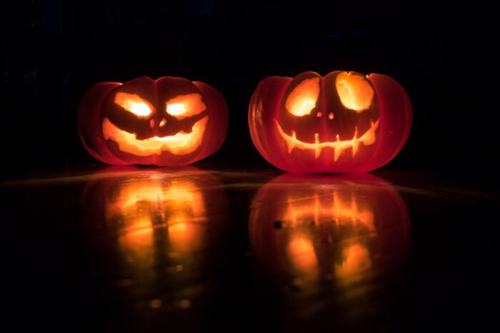 Two jack-o-lantern pumpkins lit from the inside