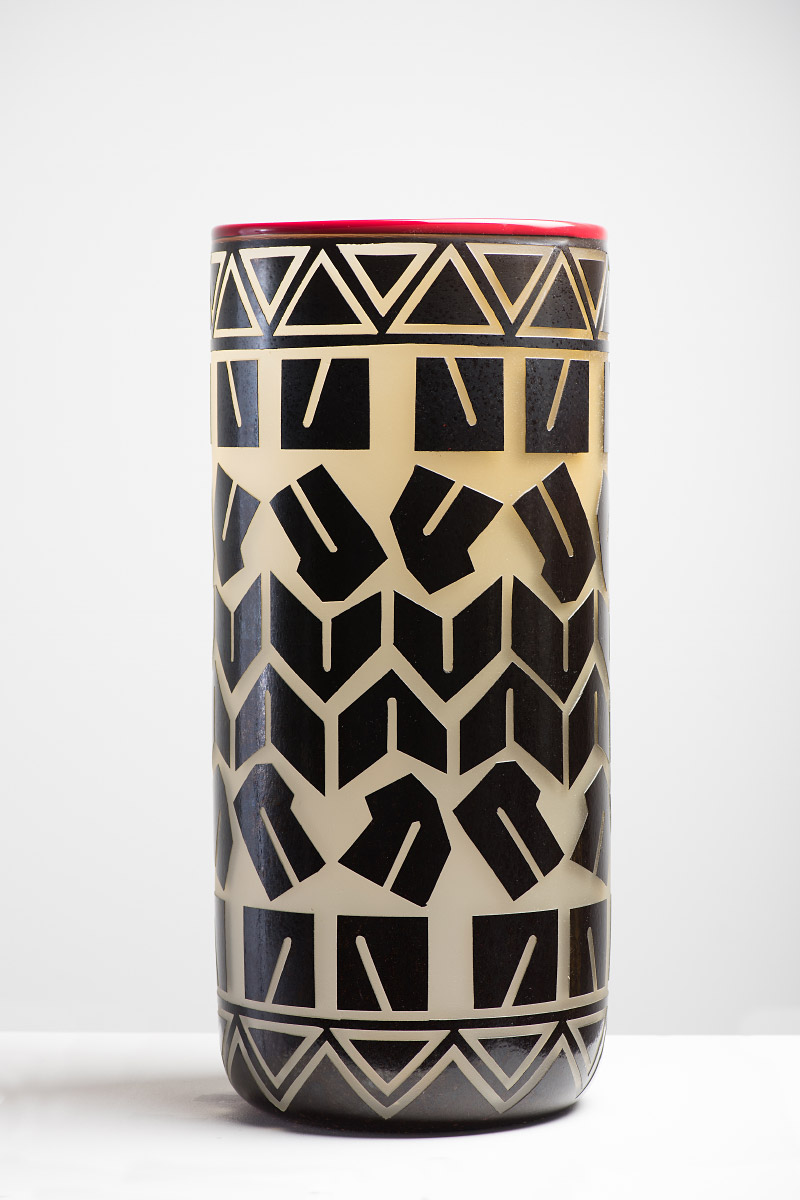 Semi-opaque glass receptacle with black geometrical decoration and a red rim