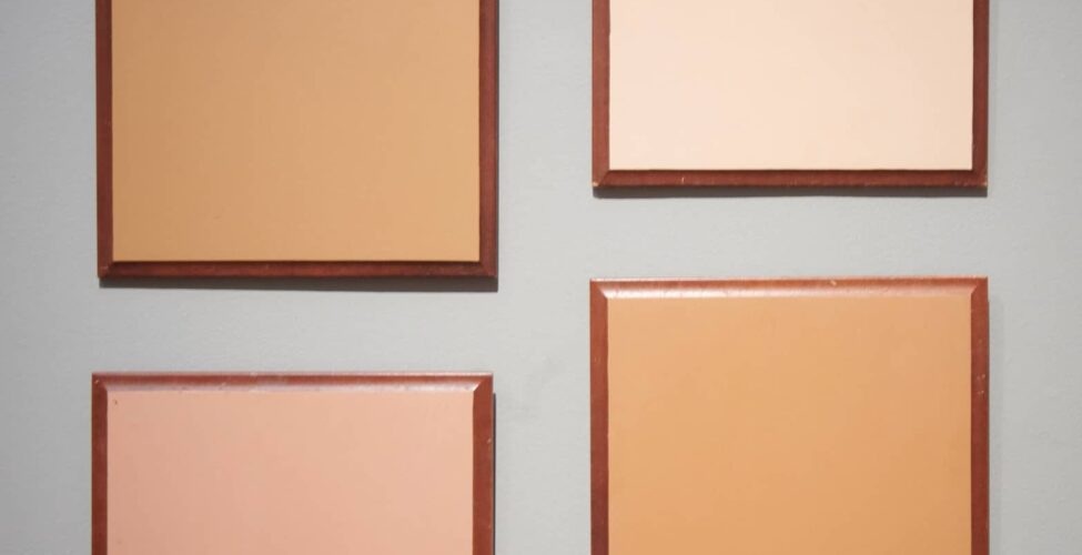 Four framed panels of different colors on a wall.