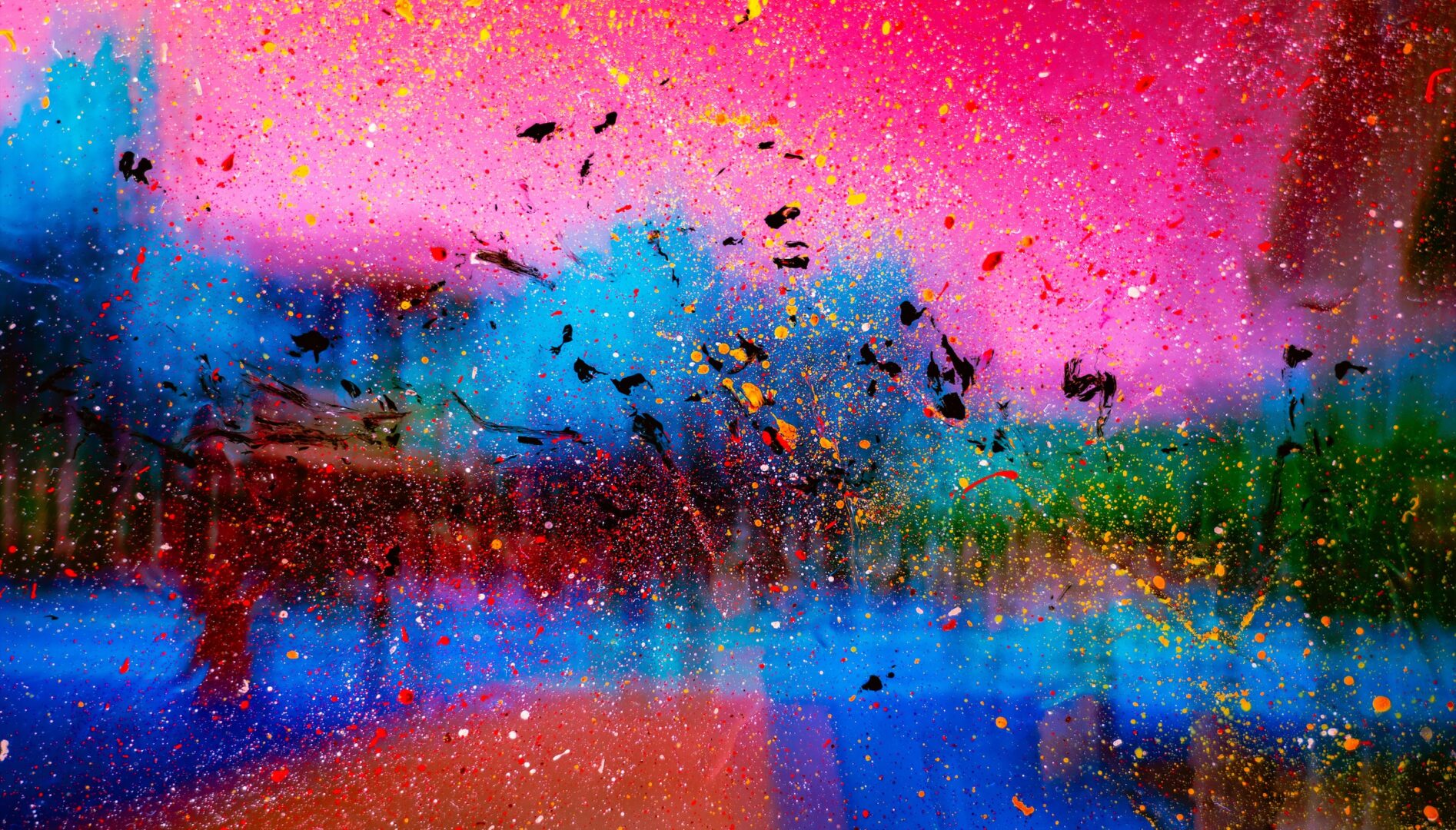 Abstract image with neon pink and blue background and paint splatters in the foreground