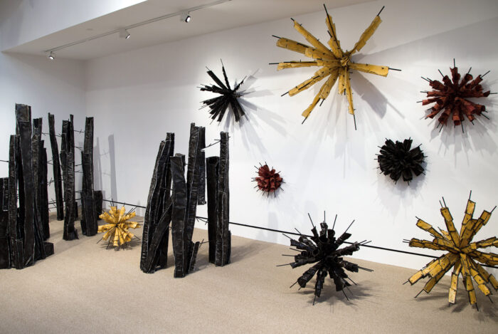 Sculptures resembling charred wood and spores in a gallery