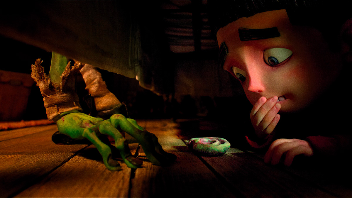 Film still from the animated movie Paranorman where a boy is looking under his bed and sees a monster's foot