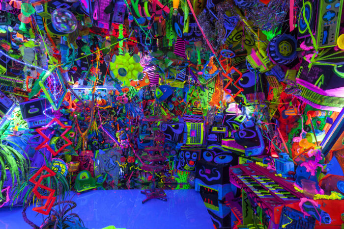 Photo of a dark room filled with day glo objects.