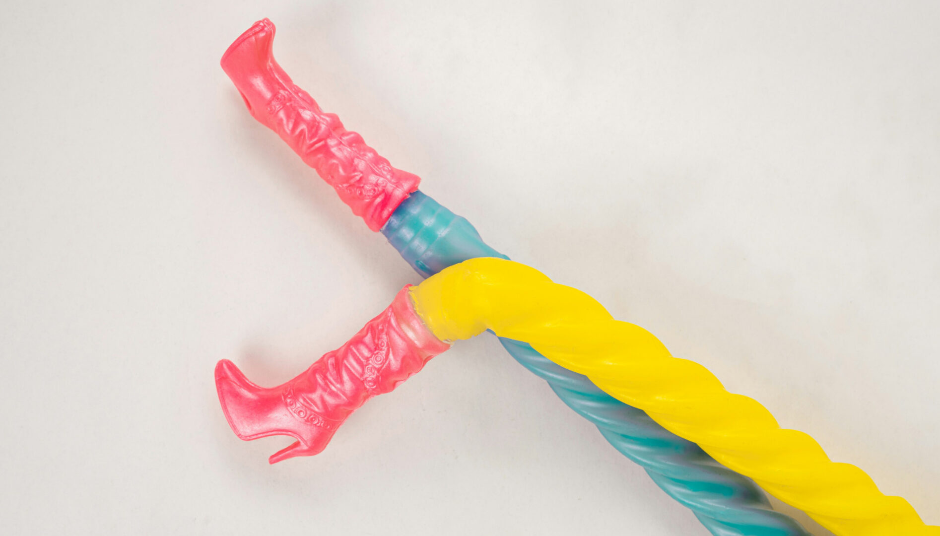 Image of pink toy boots on the end of plastic yellow and blue legs