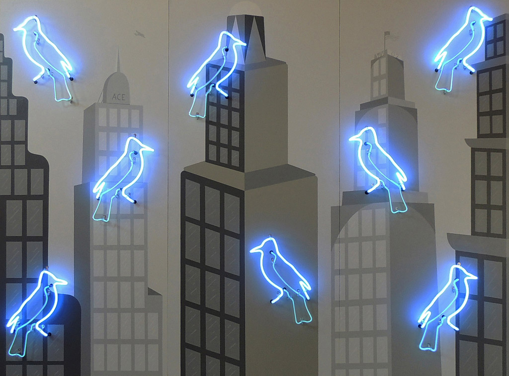 Image of black building outlines with blue neon bird shapes floating in the foreground