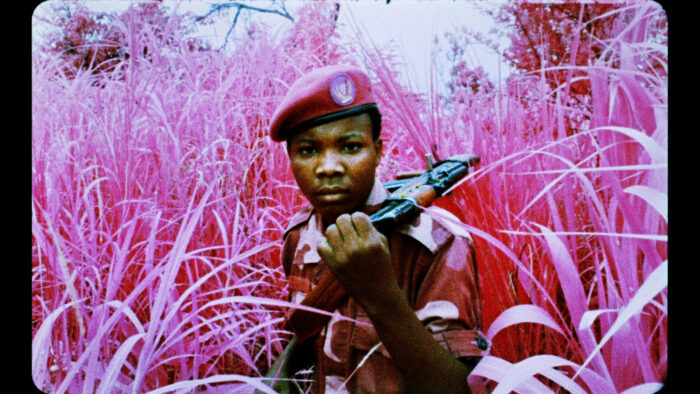 FIlm still of a Black soldier in a field of pink grass