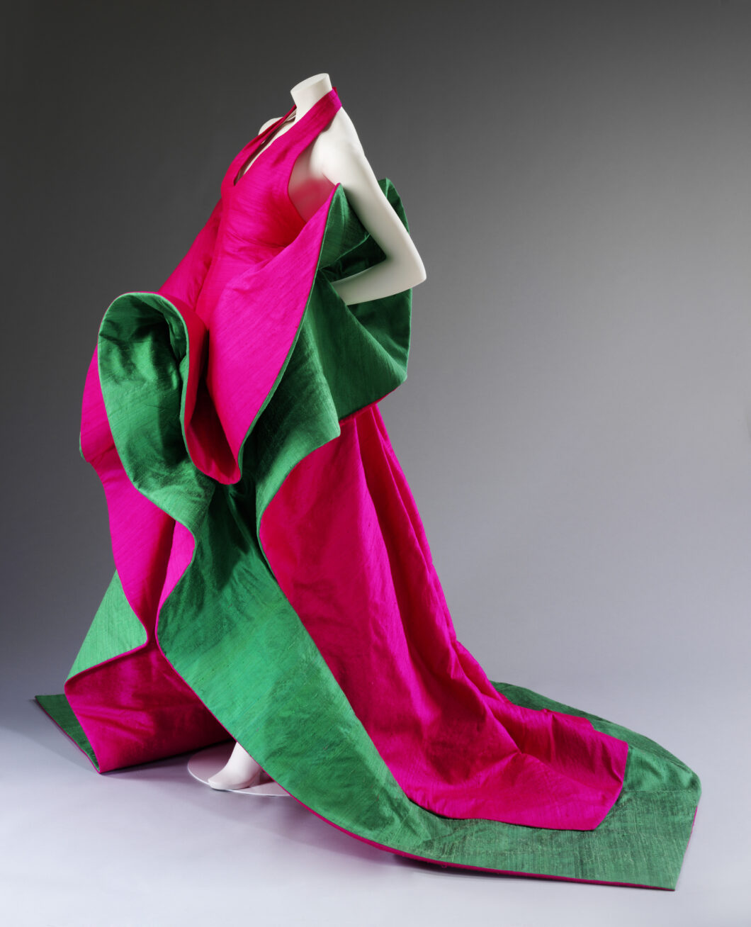 Photograph of a mannequin in a pink and green sleeveless gown