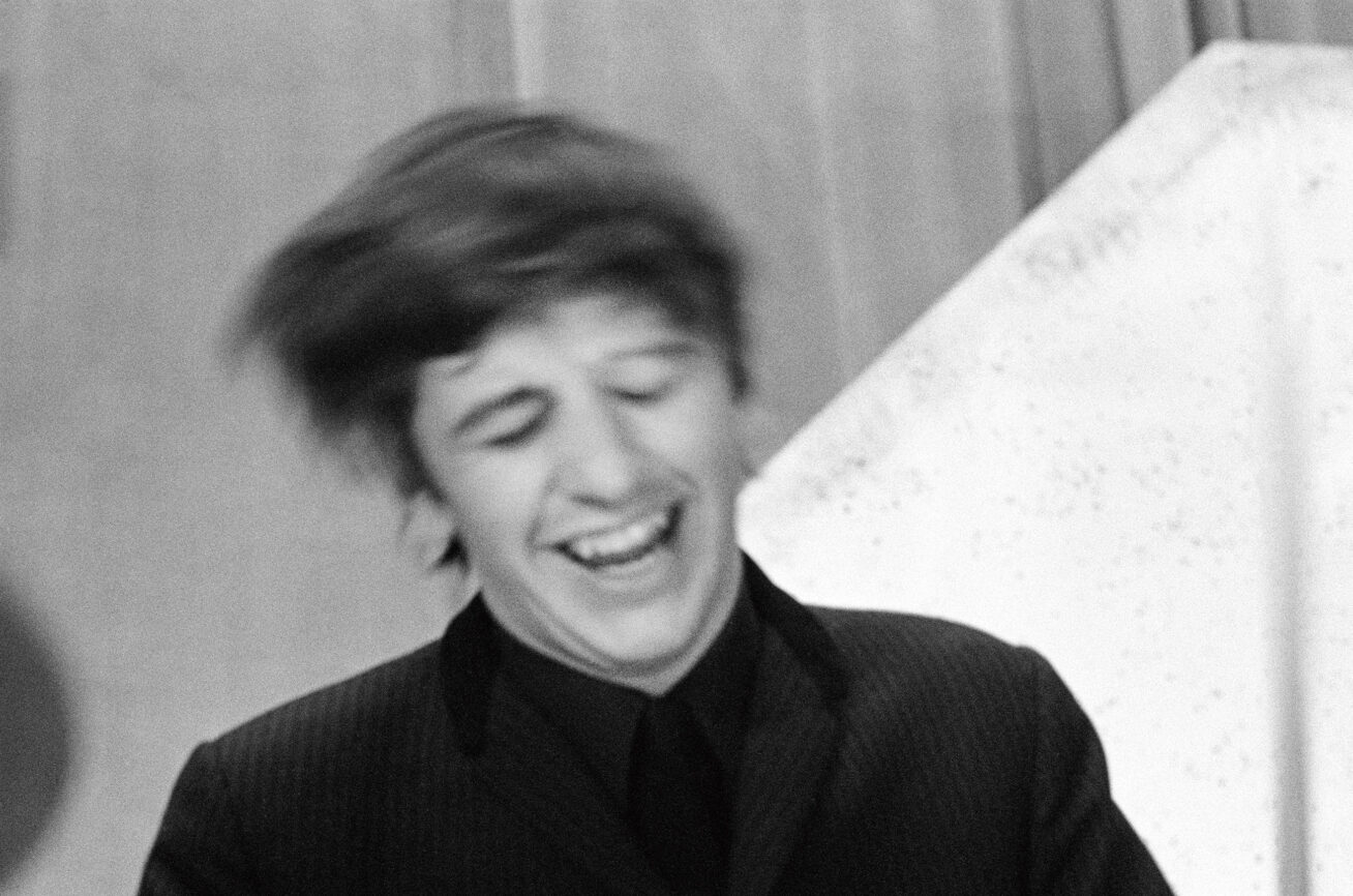 Black and white photo of Ringo Starr smiling and shaking his head