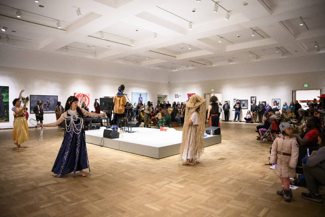 A group of dancers performing in a gallery space.