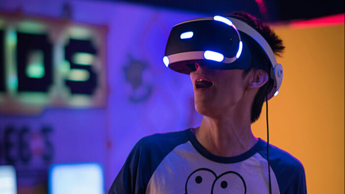 Teenager with a virtual reality headset on in a dark room