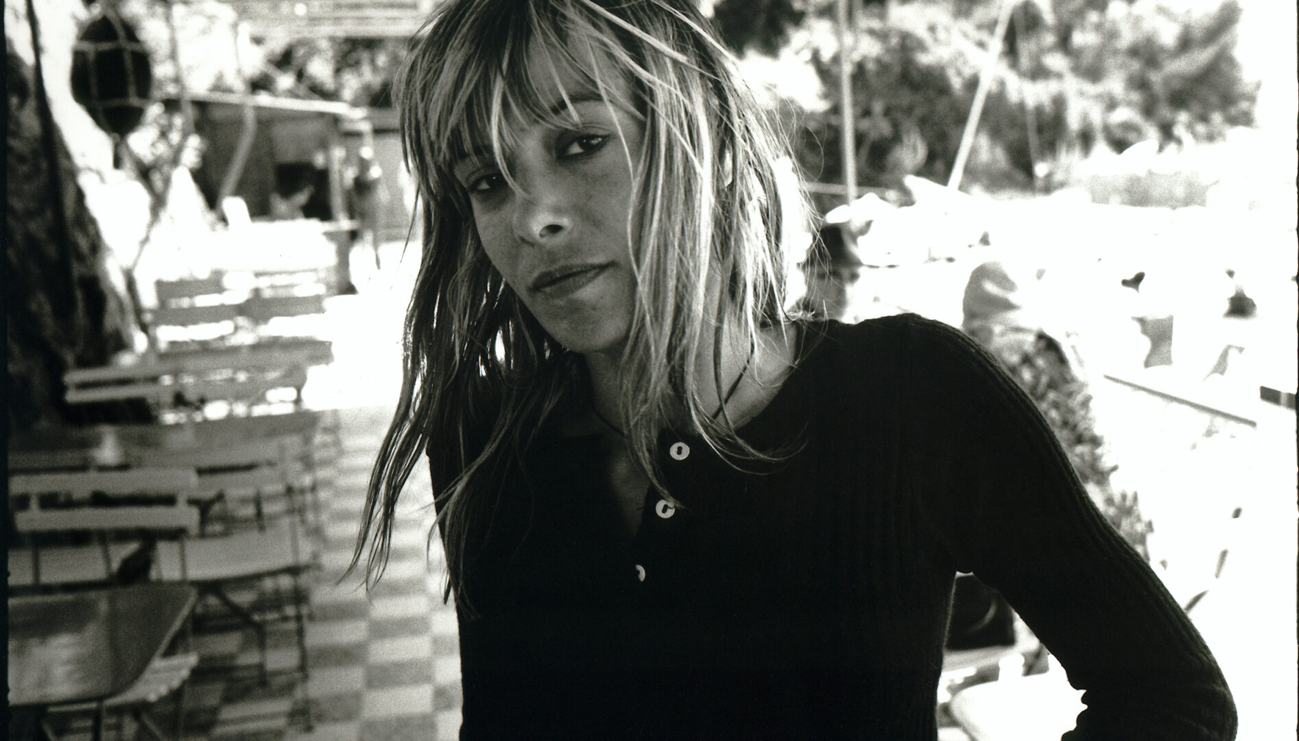 Black and white photograph of a woman with wet blonde hair, looking sideways at the camera