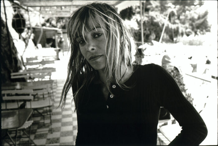 Black and white photograph of a woman with wet blonde hair, looking sideways at the camera