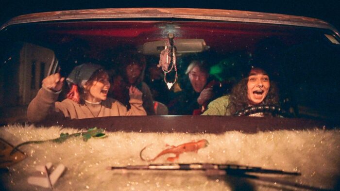 Photo of a group of happy-looking kids through a windshield