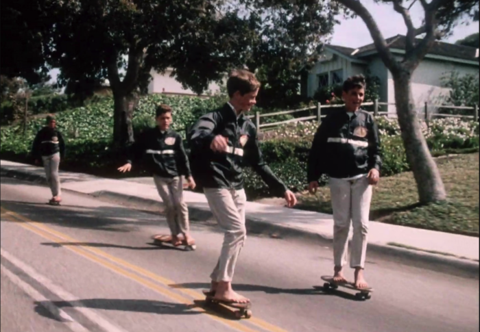 A group of boys skateboarding down a hill