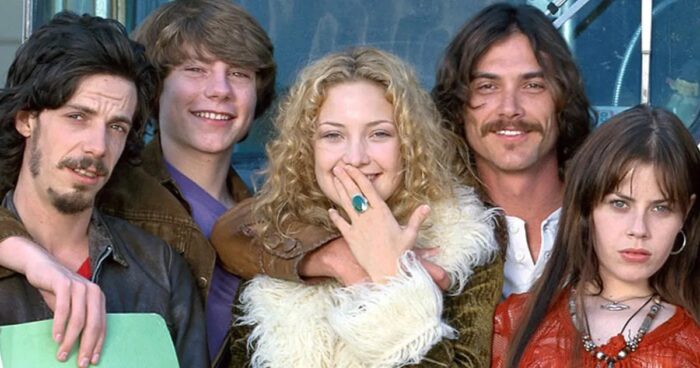 Photo of three young men and two young women smiling at the camera