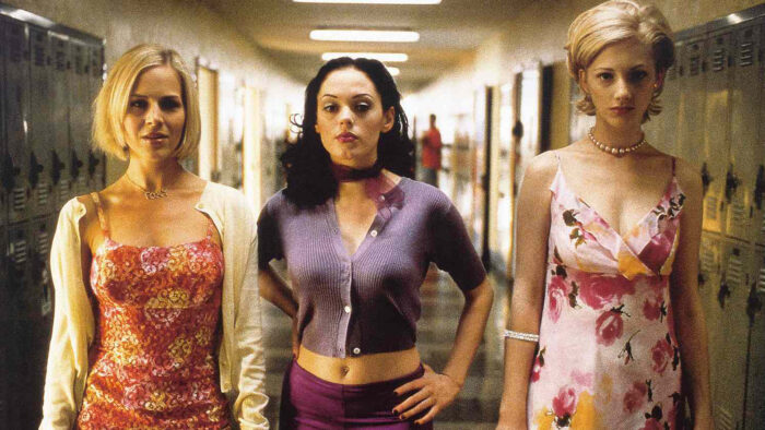 Three high school girls walking down a hallway of lockers