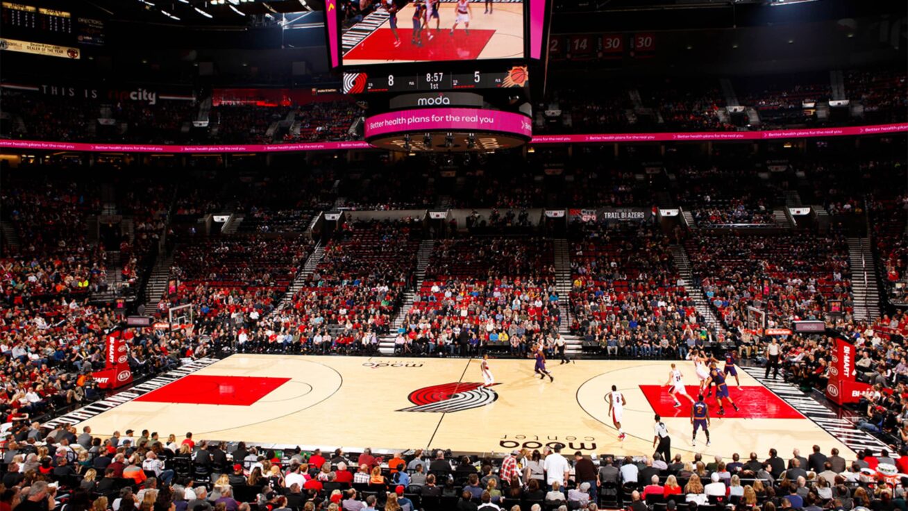 A basketball stadium with filled bleachers.