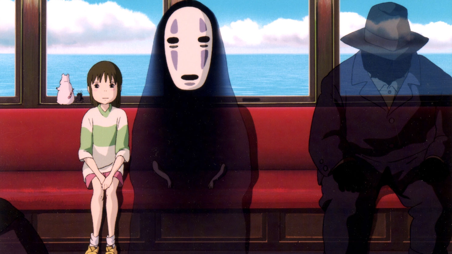 Animated film still of a young girl sitting next to a creature in a black bloak and a large oval white mask on a red seat of a train. Behind them are blue sky and clouds. A shadow of a figure with a hat is to their right.