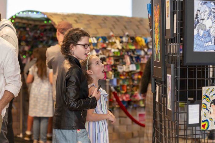 Two young girls looking at art in a gallery