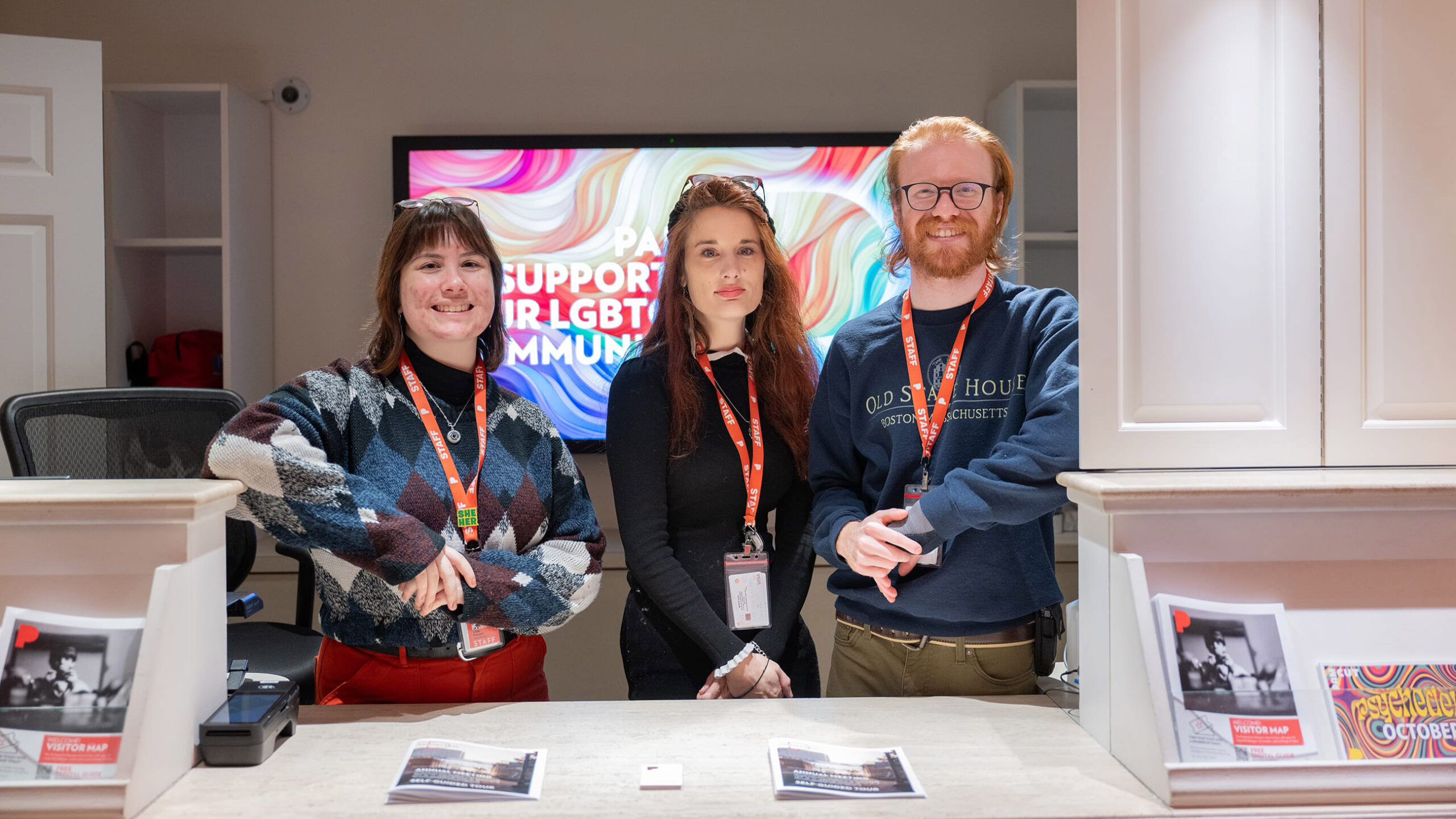 Three people standing behind a desk.