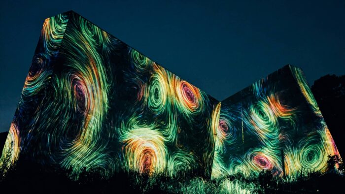 A dark wall at night with colorful, circular shapes projected upon it.