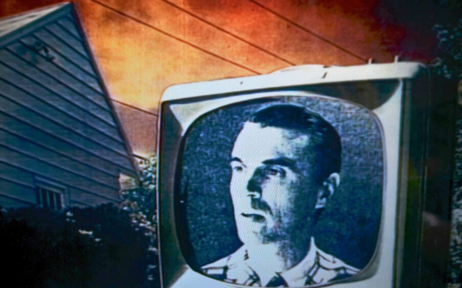 A music video film still with a black and white television with David Byrne's face on it